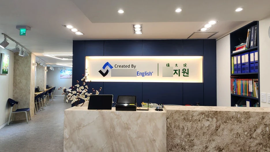 대리석 무늬 안내 데스크와 간접 조명이 있는 학원 로비 인테리어